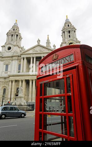 London, Großbritannien - 25. September 2020: Die berühmte rote öffentliche Telefonbox wird von der berühmten St. Paul's Cathedral im Hintergrund gesehen. Stockfoto