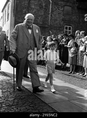 Westerham , Kent : Smiling , Herr Winston Churchill , der Premierminister , geht Hand in Hand mit seinem Enkel Nicholas Soames , während er an der Taufe von Jeremy Bernard Soames , dem zwei Monate alten achten Enkel des Premierministers , in der Westerham Parish Church teilnimmt . Das Baby ist der Sohn der Tochter des Premierministers Mary und des Hauptmanns Christopher Soames . August 1952 Stockfoto