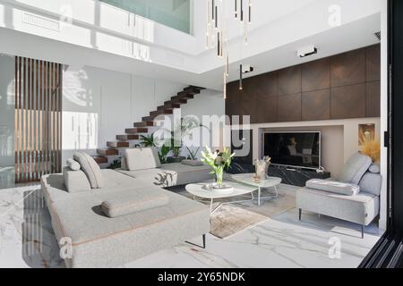 Dieses Foto zeigt ein hochwertiges, modernes Wohnzimmer in einer luxuriösen Villa mit eleganten Möbeln, elegantem Dekor und einer spektakulären Architektur Stockfoto