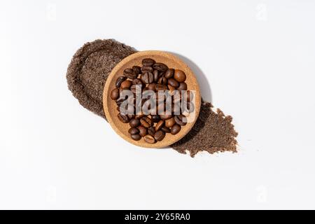 Blick von oben auf Kaffeebohnen in einer Holzschale auf einem Kaffeebad, auf einem sauberen, weißen Hintergrund, perfekt für Präsentationen auf natürlicher Hautpflege Stockfoto