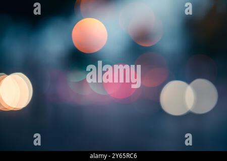 Eine wunderschöne abstrakte Komposition mit unscharfen Lichtern mit Bokeh-Effekt vor dunklem, stimmungsvollem Hintergrund, perfekt für dekorative Zwecke. Stockfoto
