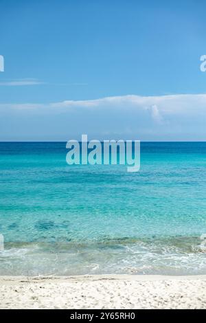 Unberührtes türkisfarbenes Wasser umgibt sanft den weißen Sandstrand unter einem hellblauen Himmel in Varadero, Kuba. Diese ruhige Strandszene bietet den perfekten Trop Stockfoto