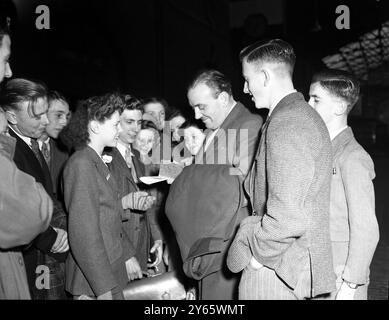 Der Anführer einer der beliebtesten Swing-Bands Großbritanniens , Ted Heath , unterzeichnet bei seiner Ankunft am Bahnhof St Pancras in London gerne Autogramme für seine begeisterten jungen Fans . 1948 Stockfoto