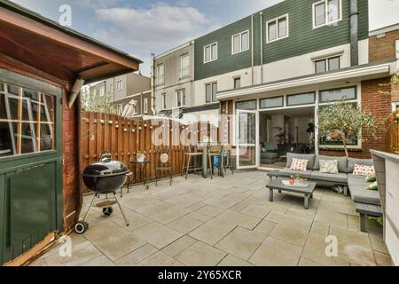 Eine gemütliche Hinterhofterrasse mit Möbeln und Grillgrill, mit Wohnbereich im Freien. Stockfoto