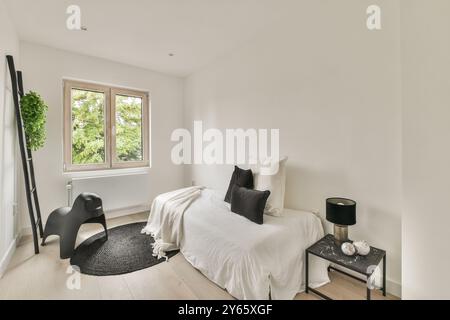 Minimalistisches Schlafzimmer mit gemütlichem Einzelbett, moderner Einrichtung und Blick auf das grüne Grün vom Fenster. Stockfoto