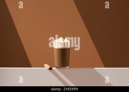 Ein köstlicher Kaffee im Affogato-Stil mit einer Schaufel Vanilleeis, garniert mit einer Kaffeebohne auf minimalistischem Hintergrund. Stockfoto
