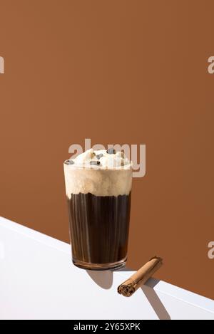 Elegantes Glas reichhaltigen Espresso mit Vanilleeis und Kaffeebohnen, mit einem Zimtstab an der Seite, das an ein luxuriöses Desserterlebnis erinnert Stockfoto