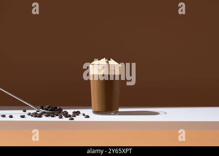 Ein erfrischendes Glas Eiskaffee mit einer Schaufel Vanilleeis und Kaffeebohnen auf der Seite sorgt für einen perfekten Sommerkaffee Stockfoto