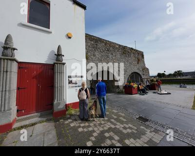 GALWAY, IRLAND - 26. JULI 2024: Die Menschen genießen musikalische Auftritte unter dem historischen Wahrzeichen des Spanischen Bogens Stockfoto