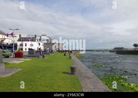 GALWAY, IRLAND - 26. JULI 2024: Die Menschen genießen den sonnigen Tag am historischen Landmark Spanish Arch Stockfoto