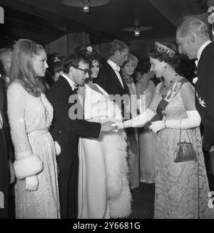 Königin Elizabeth II. Schüttelt Woody Allen im Odeon Theatre, Leicester Square, London für die Royal Film Performance 1966, wo sie den Film Born Free in Aid of the Cinema and Television Benevolent Fund sehen wird. Woody steht am 14. März 1966 zwischen Ursula Andress und Raquel Welch Stockfoto