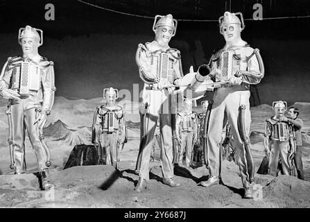 London : Lift zum Mond? Diese Mondmonster sind die Cybermen , die jüngsten Feinde von BBC's unerschrockenem Weltraumforscher Dr Who . Die Cybermen , die in Ealing Green in London zu sehen sind , werden ab Februar in einer neuen Geschichte namens Dr Who und Moonbase " erscheinen . Das Jahr ist 2070 , und der Mensch ist bereits auf dem Mond , bevor Dr. Who kommt . Aber da vor allen anderen .... The Cybermen .19 Januar 1967 Stockfoto