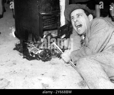 London England Dachwärmungszeremonie im New Mermaid Theatre Puddle Dock Blackfriers Norman Wisdom Britain lustiger Mann, der den Kessel von Claret bei der Zeremonie im Mermaid Theatre am 13. März 1958 anzündet Stockfoto