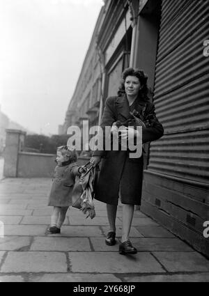 Die amerikanische GI siedelt sich nach dem Zweiten Weltkrieg in Großbritannien an und ist Tochter von GI, die vom Einkaufen nach Hause kommt . 1947 Stockfoto