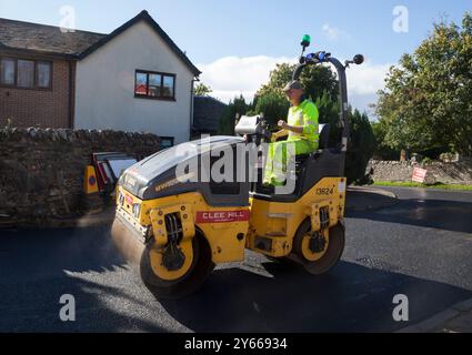 Arbeiter, der Straßenoberfläche repariert, Rhu, Schottland, zeigt kleine Straßenwalze, Rhu, Schottland Stockfoto