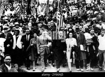 Dr. Martin Luther King ( Mitte) führt schätzungsweise 10 000 Demonstranten auf der letzten Etappe ihrer Selma - zum Montgomery bürgerrechtsmarsch . Weitere in der ersten Reihe sind John Lewis (2. Von links) von SNCC, King's Aide, Rev Ralph Abernathy (3. Von links), Dr. Ralph Bunche (5. Von links), Mrs King (neben King) und Rev Hosea Williams (Carving Little Girl) am 25. März 1965 Stockfoto