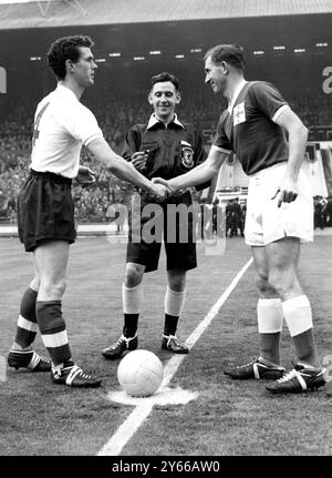 England gegen Irland bei Wembley schütteln die beiden Kapitäne, rechte Hälfte, Ronnie Clayton (links) von England und rechte Hälfte, Danny Blanchflower von Irland, vor dem Anstoß die Hand. Der Schiedsrichter ist Herr L Callaghan aus Wales. November 1959 Stockfoto