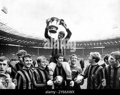 1969 FA Cup Finale Manchester City gegen Leicester City. Captain, Tony Book hält die Trophäe hoch, während er im Wembley Stadium von seinen Teamkollegen geleitet wird. (l-r) David Connor; Tommy Booth; Glyn Pardoe; Francis Lee; Mike Doyle (unterstützendes Buch auf seinen Schultern), Torhüter Harry Dowd; Colin Bell und Alan Oakes. April 1969 Stockfoto