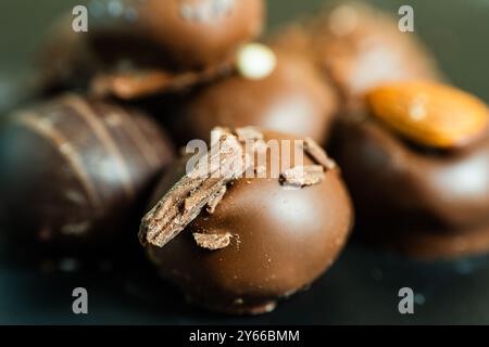 Nahaufnahme von Schokoladentrüffeln bedeckt mit Nüssen und Schokolade Stockfoto