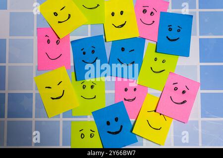 Konzeptuelles Bild verschiedener Post-its in verschiedenen Farben mit verschiedenen Smiley-Gesichtern, die Toleranz, Diversität und Inklusion darstellen. Stockfoto