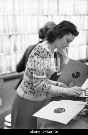 Eine junge Frau, die in einem Plattenladen Platten durchsucht. 1950er Jahre Stockfoto