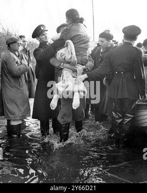 Eine barfüßige Frau wird durch die Fluten bei Jaywick Essex getragen. Februar 1953 Stockfoto