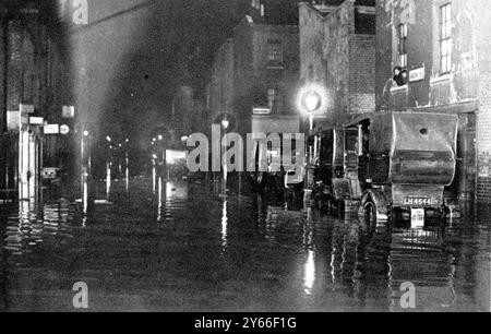 Tragödie des Platzes der Themse Embankment Wall Szene, die zeigt, wie Westminister Flut in der Dunkelheit aussah Eine Nachtszene in der Marsham Street, die in einen Kanal umgewandelt wurde, in dem Autos aufgehalten wurden. Januar 1928 Stockfoto