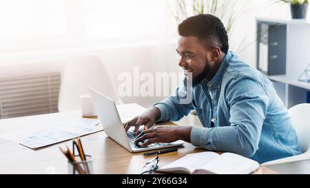 Portrait von lächelnden Mitarbeiter arbeiten am Laptop im Büro Stockfoto