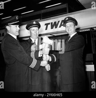 Fast Ein Rekord, der sich gestern Abend für eine kleine Feier am Londoner Flughafen Zeit genommen hat , sind diese drei Mitglieder der Trans World Airlines Flug 702 Besatzung ( von links nach rechts ) First Officer Clifford Sparrow , Captain D . W . Heath und Ingenieur Bob Hor . Die drei brachten ihren Jet Roaring von New York in fünf Stunden und 17 Minuten nach London und stellten damit fast einen Rekord für die Reise auf. Sie wurden von einem Rekord geraubt, indem sie vier Minuten lang im Flugmuster festgehalten wurden. Der Jet überquerte den Atlantik mit 127 Passagieren und zehn Besatzungsmitgliedern an Bord. Bei seiner Ankunft sagte Captain Heath, dass es so war Stockfoto