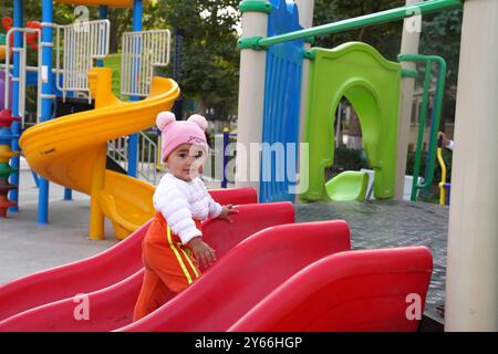 (240924) -- KASHGAR, 24. September 2024 (Xinhua) -- Ein Kind hat Spaß auf einem Spielplatz der Wohngemeinde Donghu in Kashgar, Nordwestchinas Autonomes Gebiet Xinjiang Uygur, 22. September 2024. In den letzten Jahren hat die Wohnsiedlung Donghu in Kashgar aktiv neue Modelle des Servicemanagements für Gruppen wie ältere und kleine Kinder erforscht. Das Bürgerzentrum der Gemeinde ist mit Räumen ausgestattet, darunter traditionelle chinesische Kulturakademie, Tanzstudio, Musikstudio, Malerei- und Kalligrafiestudio und psychologisches Beratungszimmer. Der Badmintonplatz, Tischtenn Stockfoto