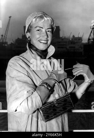 Die britische Sängerin Dorothy Squires fotografierte in Southampton bei ihrer Ankunft aus New York im Cunard-Liner Queen Mary. Sie wird an der Londoner Premiere ihres ersten Films „Stars in Your Eyes“ teilnehmen. Mit Miss Squires reiste ihr in London geborener Schauspieler Roger Moore. März 1956. Stockfoto