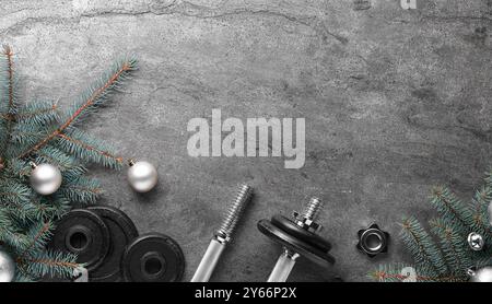 Barbell, Hantelteile und Weihnachtsdekor auf grauem Hintergrund, flache Lagen. Leerzeichen für Text Stockfoto