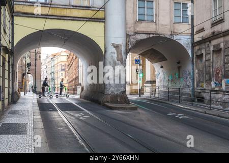 PRAG, TSCHECHISCHE REPUBLIK - 7. MAI 2023: Fußgänger auf einem Elektroroller überqueren eine Straße im historischen Zentrum der Altstadt. Stockfoto