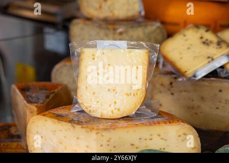 Käse in Folie geschrumpft, zum Verkauf an einem Marktstand angeboten. Käse in Folie geschrumpft, zum Verkauf an einem Marktstand angeboten. Haagse Market in den Haag, Niederlande. niederlande den haag Markt B97A6993 Stockfoto