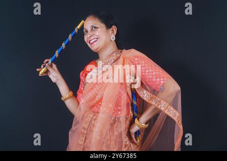 Auf diesem farbenfrohen Stockfoto werden junge indische Frauen gezeigt, die sich darauf vorbereiten, die Dandiya zu spielen, einen traditionellen Tanz während Navratri. Bereit, sich der anzunehmen Stockfoto