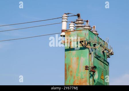 Alter Hochspannungstransformator mit Isolatoren und Drähten im Freien. Notstromausfälle. Zerstörung des Energiesystems der Ukraine. Stockfoto