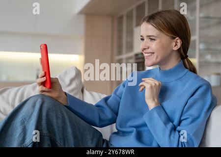 Entspannte glückliche Frau Selfie machen, Videoanruf per Telefon auf Sofa zu Hause. Online-Datum, Vorstellungsgespräch Stockfoto