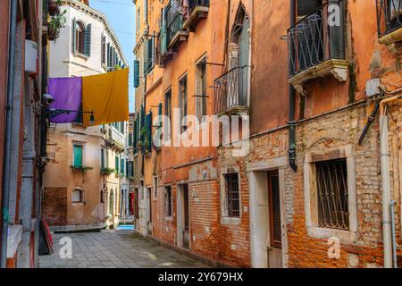 Waschen hängt zum Trocknen auf einer Linie zwischen zwei Gebäuden entlang des Rio Terà de le Carampane im Sestiere von San Polo, Venedig, Italien Stockfoto