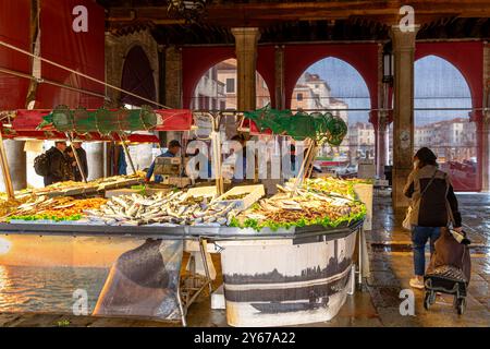 Leute kaufen frischen Fisch auf dem Rialto Fischmarkt in der San Polo Sestiere von Venedig, Italien Stockfoto