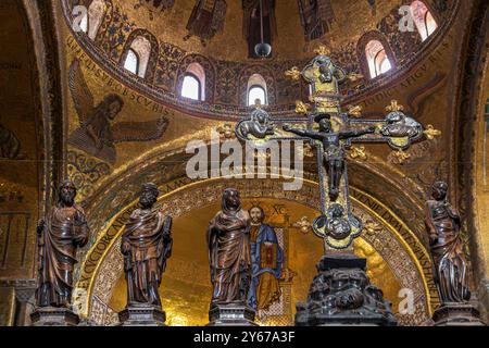 Ein Kreuz und Holzschnitzereien über dem Hochaltar des Markusdoms in Venedig, Italien Stockfoto