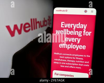 Deutschland. August 2024. In dieser Fotoabbildung hält eine Person ein Handy mit der Webseite des Wellness-Unternehmens Wellhub (Gympass US LLC) vor dem Logo. (Foto von Timon Schneider/SOPA Images/SIPA USA) *** ausschließlich für redaktionelle Nachrichten *** Credit: SIPA USA/Alamy Live News Stockfoto