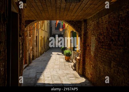 Sonnenlicht auf Sotoportego Coppo, einem kleinen Durchgang unter einem Gebäude im San Marco Sestiere von Venedig, Italien Stockfoto