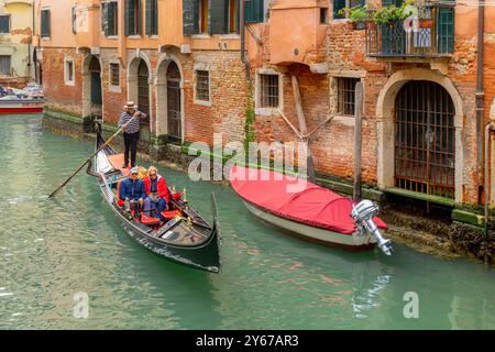 Ein Gondolierer fährt seine Gondelbahn entlang eines rio de San Lio, einem Kanal im Castello Sestiere in Venedig, Italien Stockfoto