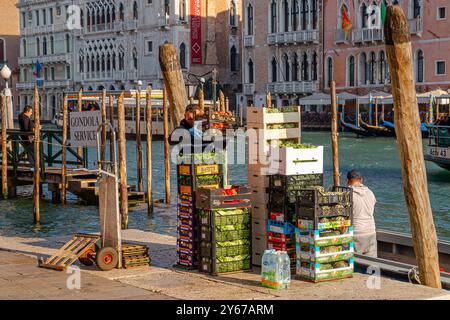 Kisten mit Obst und Gemüse, die von einem motorisierten Güterboot entladen werden und auf dem Rialto-Markt im San Polo Sestiere in Venedig, Italien, verkauft werden können Stockfoto