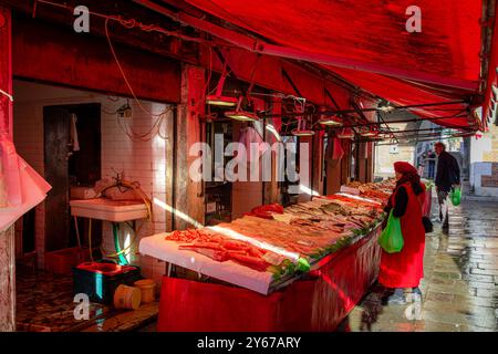 Leute kaufen frischen Fisch auf dem Rialto Fischmarkt in der San Polo Sestiere von Venedig, Italien Stockfoto