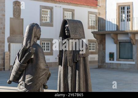 Monumento a los Mirandeses, Metallskulpturen eines Mannes und einer Frau in traditioneller Mirandes-Kleidung, auf einem kleinen Platz, Miranda do Douro, Portugal Stockfoto