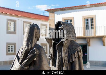 Monumento a los Mirandeses, Metallskulpturen eines Mannes und einer Frau in traditioneller Mirandes-Kleidung, auf einem kleinen Platz, Miranda do Douro, Portugal Stockfoto