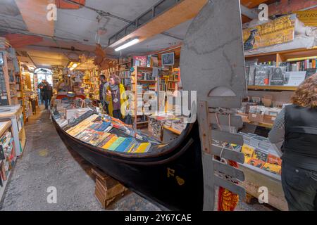 In der Libreria Acqua Alta, einem skurrilen, beliebten Buchladen im Castello Sestiere in Venedig, Italien, stöbern Leute nach Büchern Stockfoto