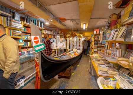 In der Libreria Acqua Alta, einem skurrilen, beliebten Buchladen im Castello Sestiere in Venedig, Italien, stöbern Leute nach Büchern Stockfoto