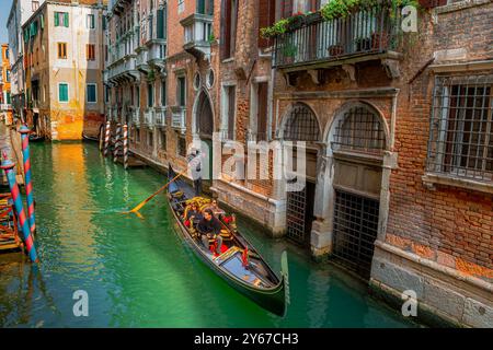 Touristen, die eine Gondelfahrt entlang des Rio de L'Barcaroli Unternehmen, einem Kanal im San Marco Sestiere von Venedig, Italien Stockfoto